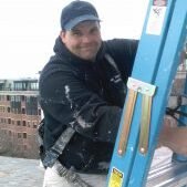 Frank painting on a ladder.